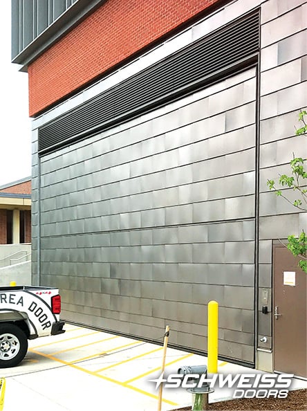 University of Mass's Schweiss door is clad with Aluminum plank at their South College Academic Facility 